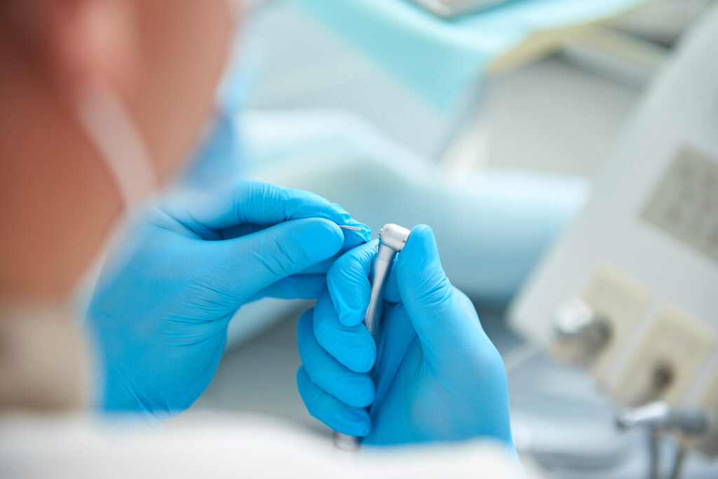 Male dentist is preparing for dental procedure